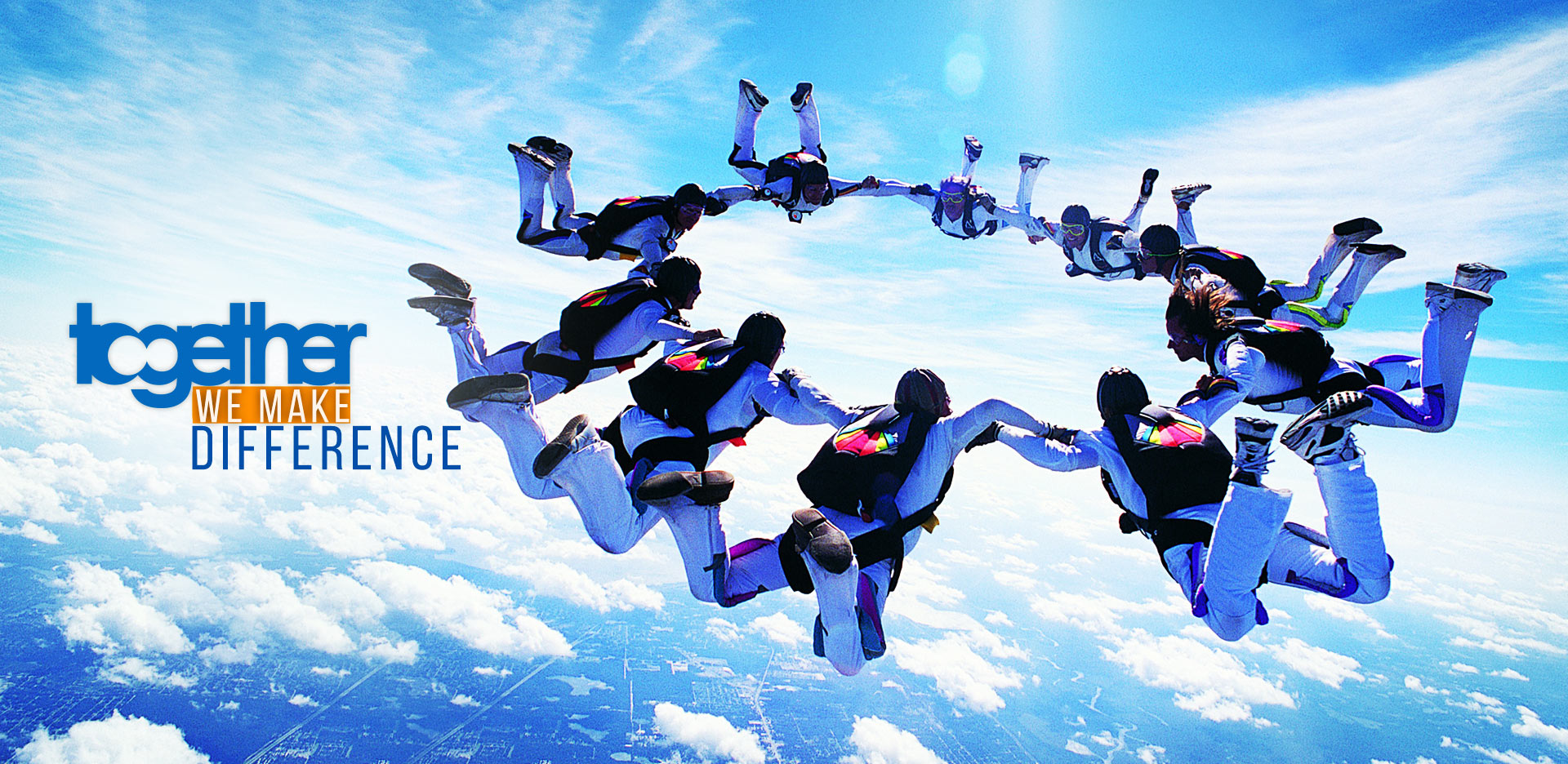 Together. We make difference: skydivers holding hands in a circle in a blue sky
